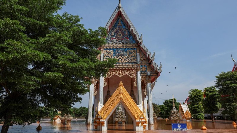 Patung-patung Buddha sebagian terendam di tepi sungai yang banjir akibat hujan deras dan luapan sungai, dengan Ayutthaya sebagai salah satu daerah yang paling parah terkena dampaknya, di distrik Bang Ban, provinsi Ayutthaya, Thailand, 8 Oktober 2025. REUTERS/Chalinee Thirasupa