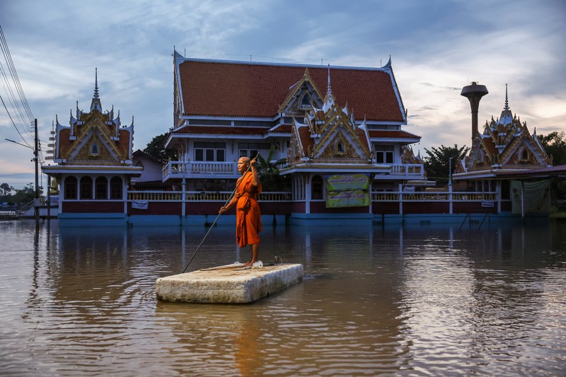 Patung-patung Buddha sebagian terendam di tepi sungai yang banjir akibat hujan deras dan luapan sungai, dengan Ayutthaya sebagai salah satu daerah yang paling parah terkena dampaknya, di distrik Bang Ban, provinsi Ayutthaya, Thailand, 8 Oktober 2025. REUTERS/Chalinee Thirasupa