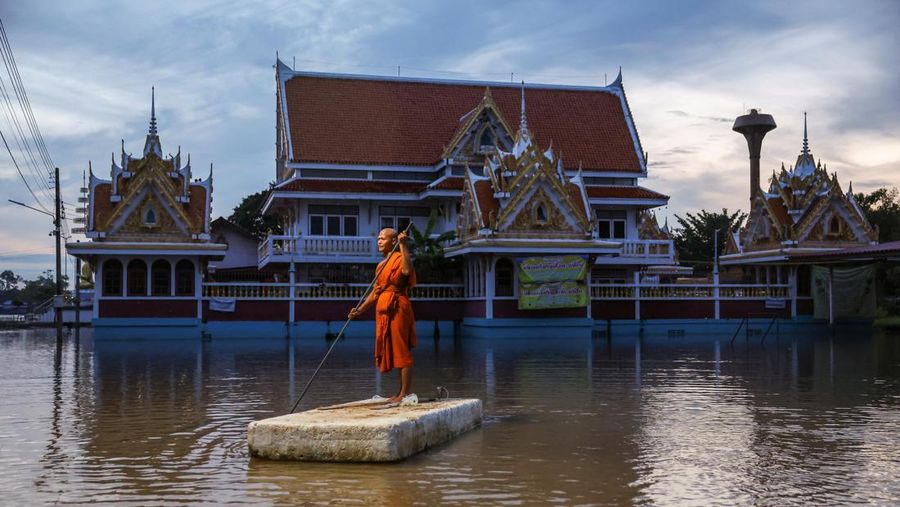 Patung-patung Buddha sebagian terendam di tepi sungai yang banjir akibat hujan deras dan luapan sungai, dengan Ayutthaya sebagai salah satu daerah yang paling parah terkena dampaknya, di distrik Bang Ban, provinsi Ayutthaya, Thailand, 8 Oktober 2025. REUTERS/Chalinee Thirasupa