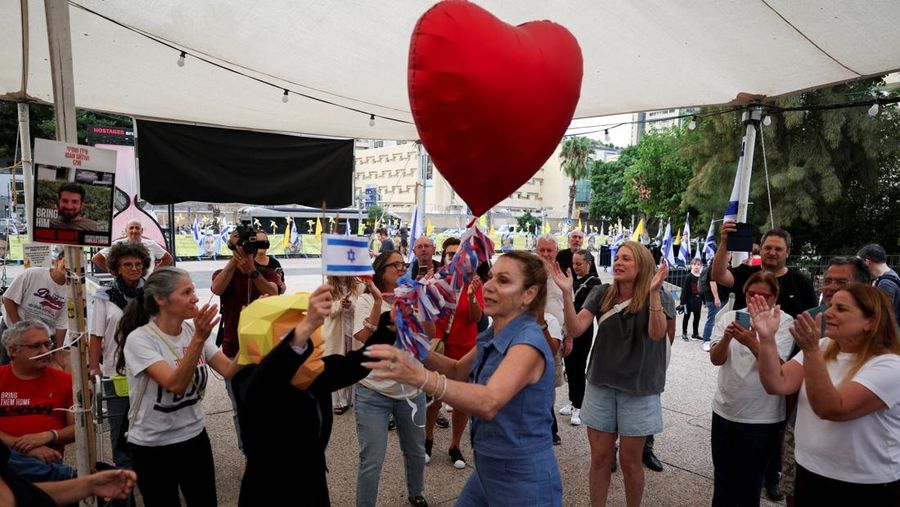 ISRAEL-PALESTINIANS/ Seorang pria mengenakan topeng bergambar Presiden AS Donald Trump memegang bendera Israel dan balon berbentuk hati, sementara orang-orang merayakan setelah Trump mengumumkan bahwa Israel dan Hamas menyepakati fase pertama gencatan senjata Gaza, di