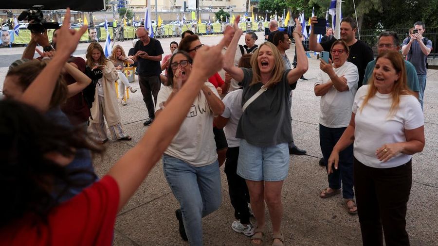 ISRAEL-PALESTINIANS/ Seorang pria mengenakan topeng bergambar Presiden AS Donald Trump memegang bendera Israel dan balon berbentuk hati, sementara orang-orang merayakan setelah Trump mengumumkan bahwa Israel dan Hamas menyepakati fase pertama gencatan senjata Gaza, di