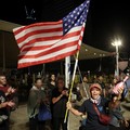 Seorang perempuan bereaksi sambil membawa bendera AS saat orang-orang merayakan setelah Presiden AS Donald Trump mengumumkan bahwa Israel dan Hamas menyepakati fase pertama gencatan senjata Gaza, di "Lapangan Sandera", di Tel Aviv, Israel, 9 Oktober