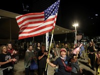 Seorang perempuan bereaksi sambil membawa bendera AS saat orang-orang merayakan setelah Presiden AS Donald Trump mengumumkan bahwa Israel dan Hamas menyepakati fase pertama gencatan senjata Gaza, di "Lapangan Sandera", di Tel Aviv, Israel, 9 Oktober