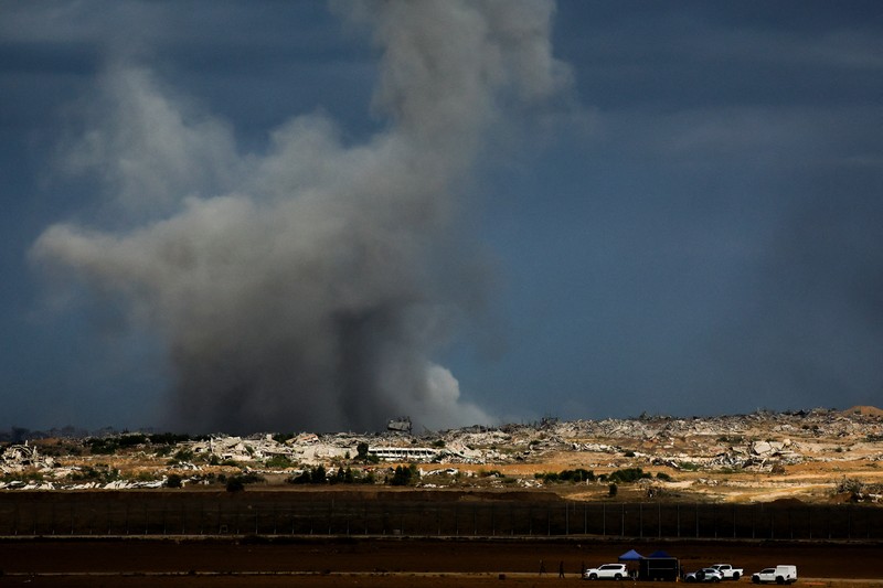 ISRAEL-PALESTINIANS/GAZA Asap mengepul dari Gaza, setelah Presiden AS Donald Trump mengumumkan bahwa Israel dan Hamas menyepakati fase pertama gencatan senjata di Gaza, seperti yang terlihat dari sisi perbatasan Israel dengan Gaza, 9 Oktober 2025. REUTERS/Ammar Awad