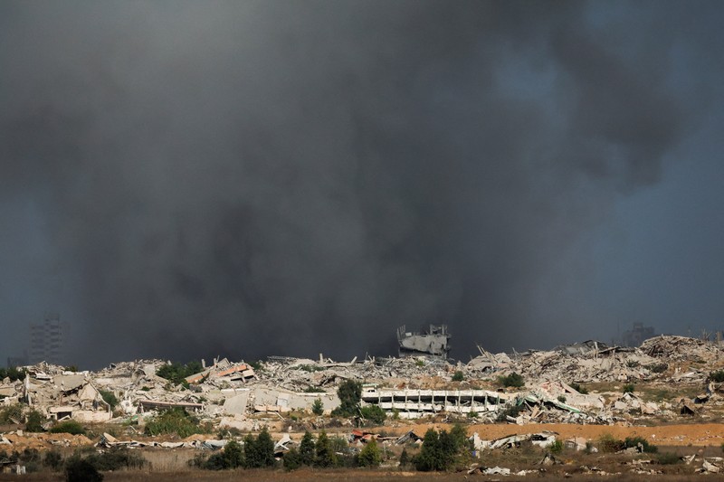 ISRAEL-PALESTINIANS/GAZA Asap mengepul dari Gaza, setelah Presiden AS Donald Trump mengumumkan bahwa Israel dan Hamas menyepakati fase pertama gencatan senjata di Gaza, seperti yang terlihat dari sisi perbatasan Israel dengan Gaza, 9 Oktober 2025. REUTERS/Ammar Awad