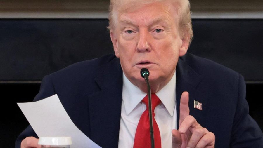 U.S. President Donald Trump holds a note that was handed to him by U.S. Secretary of State Marco Rubio during a roundtable on antifa, an anti-fascist movement Trump designated a domestic