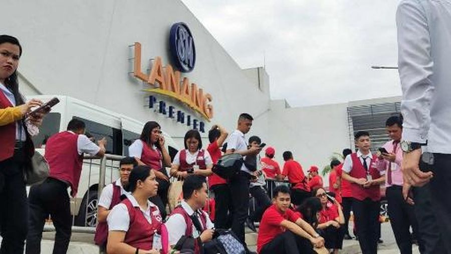 Para karyawan sebuah pusat perbelanjaan berkumpul di luar gedung di Kota Davao, di pulau selatan Mindanao, pada 10 Oktober 2025, setelah gempa berkekuatan 7,4 skala Richter melanda Filipina selatan.(Photo by Bobbie ALOTA / AFP)