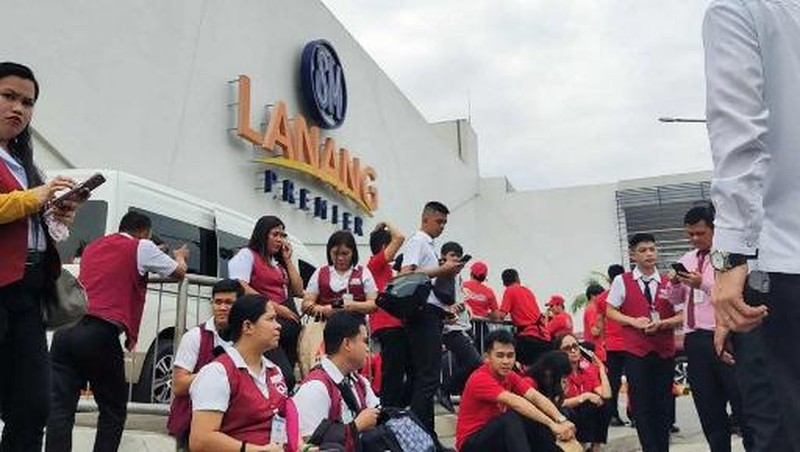 Para karyawan sebuah pusat perbelanjaan berkumpul di luar gedung di Kota Davao, di pulau selatan Mindanao, pada 10 Oktober 2025, setelah gempa berkekuatan 7,4 skala Richter melanda Filipina selatan.(Photo by Bobbie ALOTA / AFP)