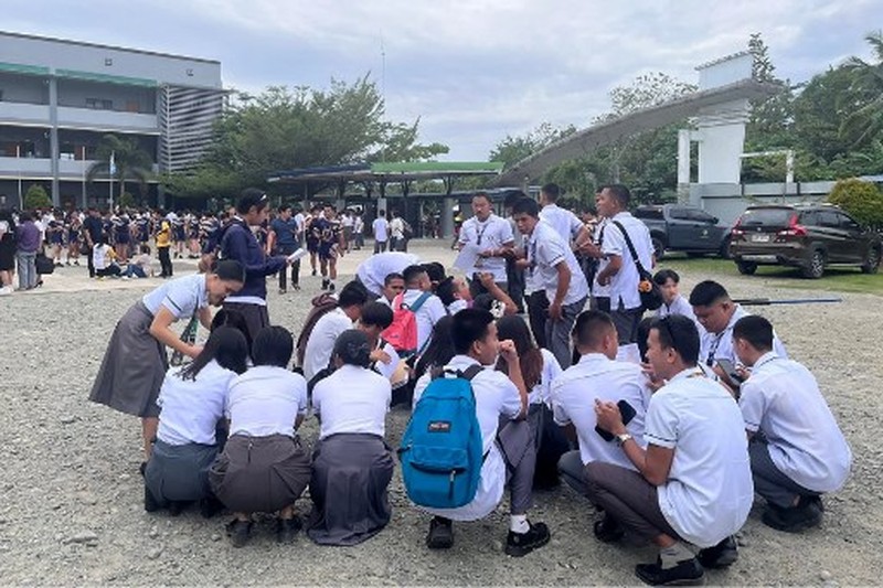 Para karyawan sebuah pusat perbelanjaan berkumpul di luar gedung di Kota Davao, di pulau selatan Mindanao, pada 10 Oktober 2025, setelah gempa berkekuatan 7,4 skala Richter melanda Filipina selatan.(Photo by Bobbie ALOTA / AFP)