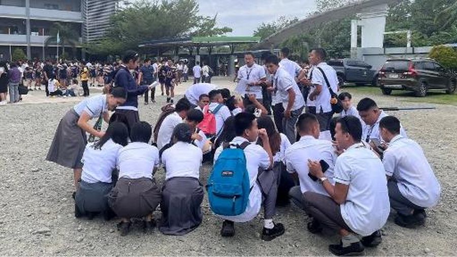 Para karyawan sebuah pusat perbelanjaan berkumpul di luar gedung di Kota Davao, di pulau selatan Mindanao, pada 10 Oktober 2025, setelah gempa berkekuatan 7,4 skala Richter melanda Filipina selatan.(Photo by Bobbie ALOTA / AFP)
