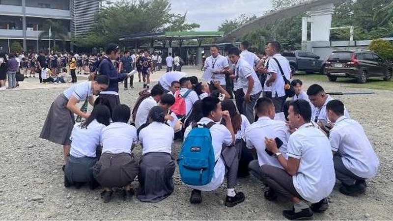 Para karyawan sebuah pusat perbelanjaan berkumpul di luar gedung di Kota Davao, di pulau selatan Mindanao, pada 10 Oktober 2025, setelah gempa berkekuatan 7,4 skala Richter melanda Filipina selatan.(Photo by Bobbie ALOTA / AFP)