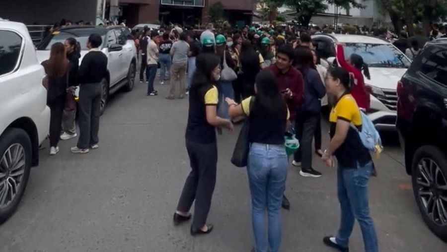 Para karyawan sebuah pusat perbelanjaan berkumpul di luar gedung di Kota Davao, di pulau selatan Mindanao, pada 10 Oktober 2025, setelah gempa berkekuatan 7,4 skala Richter melanda Filipina selatan.(Photo by Bobbie ALOTA / AFP)