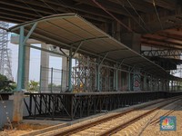Warga berjalan melintas di dekat proyek Stasiun Jakarta International Stadium (JIS) di kawasan Tanjung Priok, Jakarta, Jumat (10/10/2025). (CNBC Indonesia/Faisal Rahman)