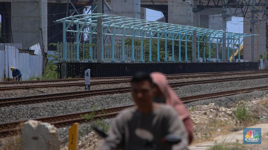 Warga berjalan melintas di dekat proyek Stasiun Jakarta International Stadium (JIS) di kawasan Tanjung Priok, Jakarta, Jumat (10/10/2025). (CNBC Indonesia/Faisal Rahman)