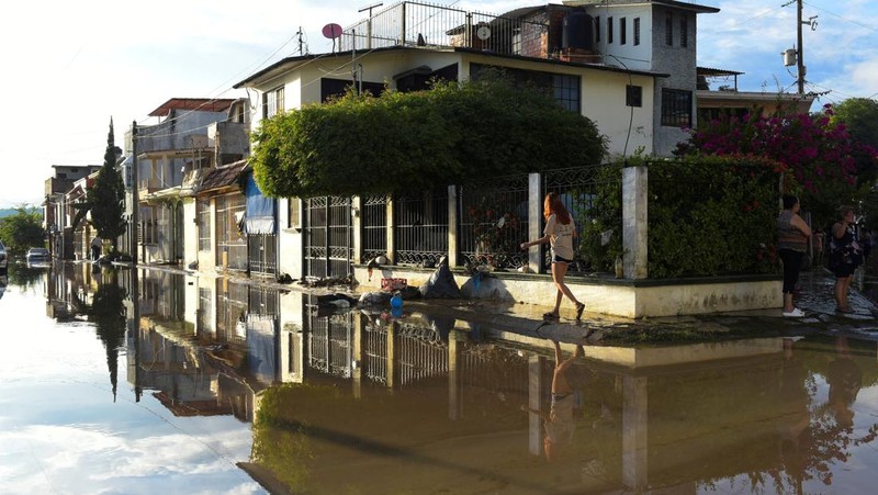 Warga terkena dampak hujan lebat yang menyebabkan meluapnya sungai di Poza Rica, negara bagian Veracruz, Meksiko, Jumat (10/10/2025). (REUTERS/Rolando Ramos)