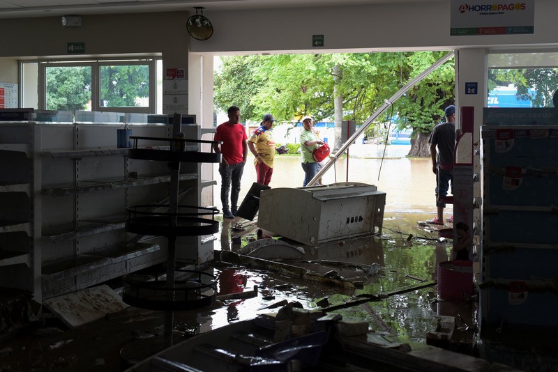 Warga terkena dampak hujan lebat yang menyebabkan meluapnya sungai di Poza Rica, negara bagian Veracruz, Meksiko, Jumat (10/10/2025). Warga terkena dampak hujan lebat yang menyebabkan meluapnya sungai di Poza Rica, negara bagian Veracruz, Meksiko, Jumat (10/10/2025). (REUTERS/Rolando Ramos)