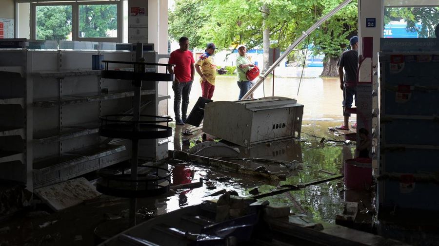 Warga terkena dampak hujan lebat yang menyebabkan meluapnya sungai di Poza Rica, negara bagian Veracruz, Meksiko, Jumat (10/10/2025). (REUTERS/Rolando Ramos)