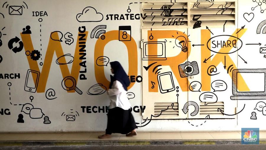 Seorang pekerja melintas di depan mural ilustrasi di Kementerian Ketenagakerjaan, Jakarta Selatan, Senin, (13/10/2025). (CNBC Indonesia/Muhammad Sabki)