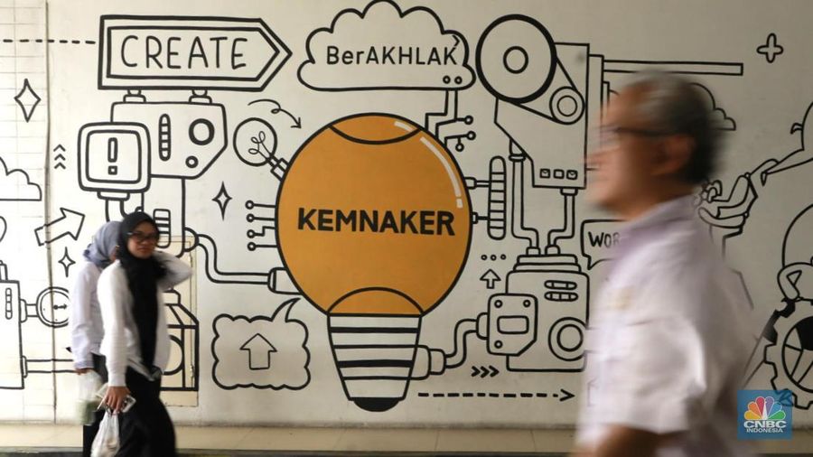 Seorang pekerja melintas di depan mural ilustrasi di Kementerian Ketenagakerjaan, Jakarta Selatan, Senin, (13/10/2025). (CNBC Indonesia/Muhammad Sabki)