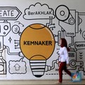 Seorang pekerja melintas di depan mural ilustrasi di Kementerian Ketenagakerjaan, Jakarta Selatan, Senin, (13/10/2025). (CNBC Indonesia/Muhammad Sabki)