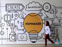 Seorang pekerja melintas di depan mural ilustrasi di Kementerian Ketenagakerjaan, Jakarta Selatan, Senin, (13/10/2025). (CNBC Indonesia/Muhammad Sabki)