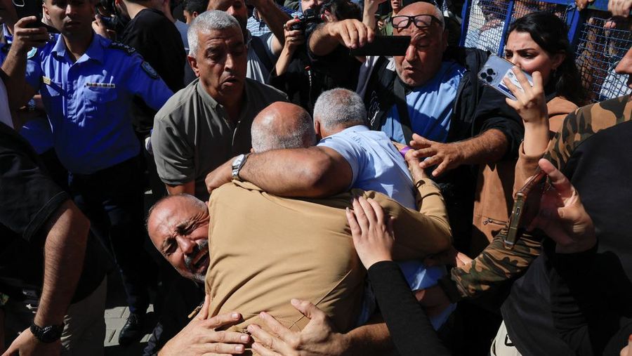 Tahanan Palestina yang dibebaskan berpelukan setelah dibebaskan dari penjara Israel sebagai bagian dari pertukaran sandera tahanan dan kesepakatan gencatan senjata di Gaza antara Hamas dan Israel, di Ramallah, Tepi Barat yang diduduki Israel, Senin (13/10/2025). (REUTERS/Mussa Qawasma)