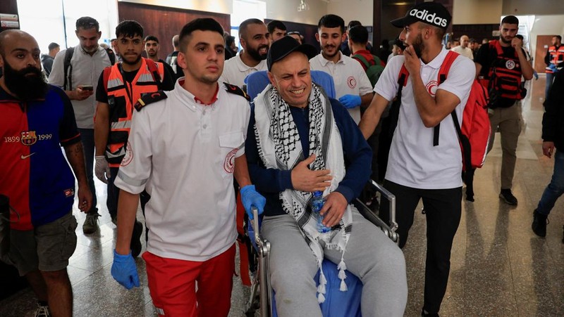 Tahanan Palestina yang dibebaskan berpelukan setelah dibebaskan dari penjara Israel sebagai bagian dari pertukaran sandera tahanan dan kesepakatan gencatan senjata di Gaza antara Hamas dan Israel, di Ramallah, Tepi Barat yang diduduki Israel, Senin (13/10/2025). (REUTERS/Mussa Qawasma)