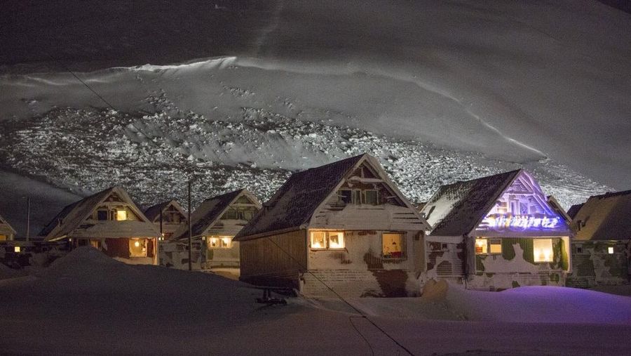Lampu bersinar di dalam rumah-rumah yang dievakuasi setelah longsor melanda Longyearbyen di Svalbard, Norwegia, 19 Desember 2015. (Photo by Tore Meek / various sources / AFP/File Foto)