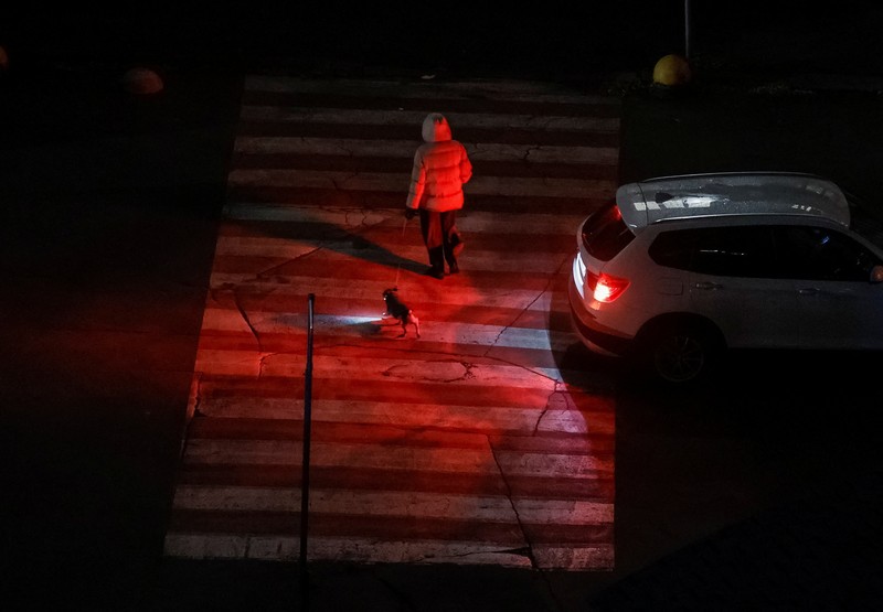 Seorang wanita menyeberang jalan dengan anjingnya saat listrik padam setelah infrastruktur sipil penting terkena serangan rudal dan pesawat tak berawak Rusia baru-baru ini, di tengah serangan Rusia terhadap Ukraina, di Kyiv, Ukraina, 14 Oktober 2025. Seorang wanita menyeberang jalan dengan anjingnya saat listrik padam setelah infrastruktur sipil penting terkena serangan rudal dan pesawat tak berawak Rusia baru-baru ini, di tengah serangan Rusia terhadap Ukraina, di Kyiv, Ukraina, 14 Oktober 2025. (REUTERS/Gleb Garanich)