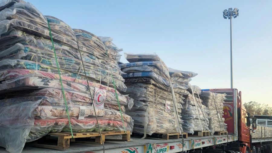 Para relawan Mesir beristirahat dan duduk di samping truk-truk yang membawa bantuan kemanusiaan dari Aliansi Nasional Mesir untuk Pekerjaan Pembangunan Sipil (NACDW) saat mereka menuju perbatasan Rafah untuk memasuki Gaza, setelah gencatan senjata antara Israel dan Hamas di Gaza berlaku, di jalan gurun Kairo-Ismailia, Mesir, 16 Oktober 2025. (REUTERS/Amr Abdallah Dalsh)