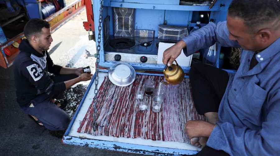 Para relawan Mesir beristirahat dan duduk di samping truk-truk yang membawa bantuan kemanusiaan dari Aliansi Nasional Mesir untuk Pekerjaan Pembangunan Sipil (NACDW) saat mereka menuju perbatasan Rafah untuk memasuki Gaza, setelah gencatan senjata antara Israel dan Hamas di Gaza berlaku, di jalan gurun Kairo-Ismailia, Mesir, 16 Oktober 2025. (REUTERS/Amr Abdallah Dalsh)