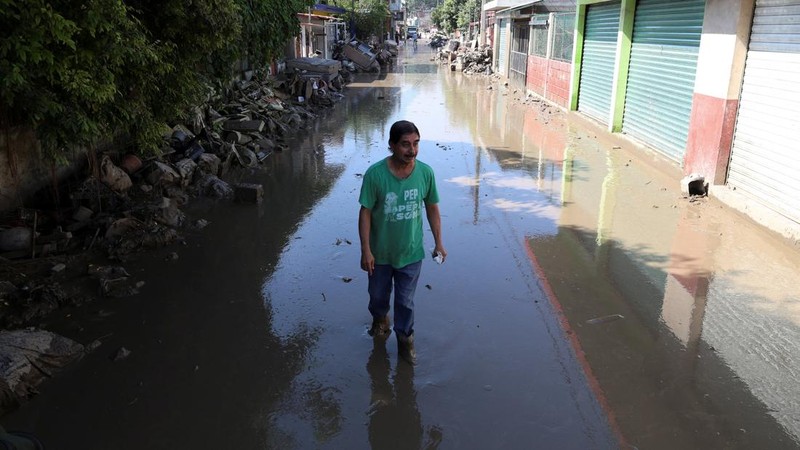 Tim relawan bergotong royong membantu warga yang terisolasi akibat banjir besar di Meksiko bagian tengah dan timur. Bencana ini telah menewaskan sedikitnya 64 orang, sementara 65 lainnya dilaporkan hilang, Jumat (17/10/2025). (REUTERS/Henry Romero)