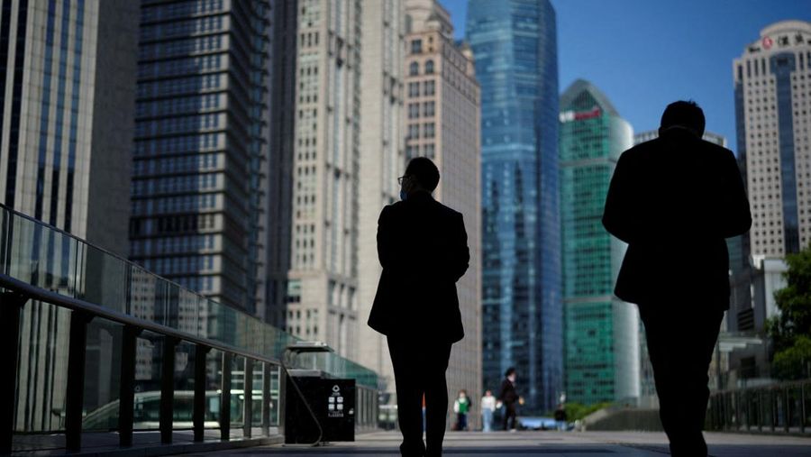 Orang-orang berjalan melewati menara perkantoran di distrik keuangan Lujiazui, Shanghai, Cina, 17 Oktober 2022. (REUTERS/Aly Song/File Photo/File Foto)