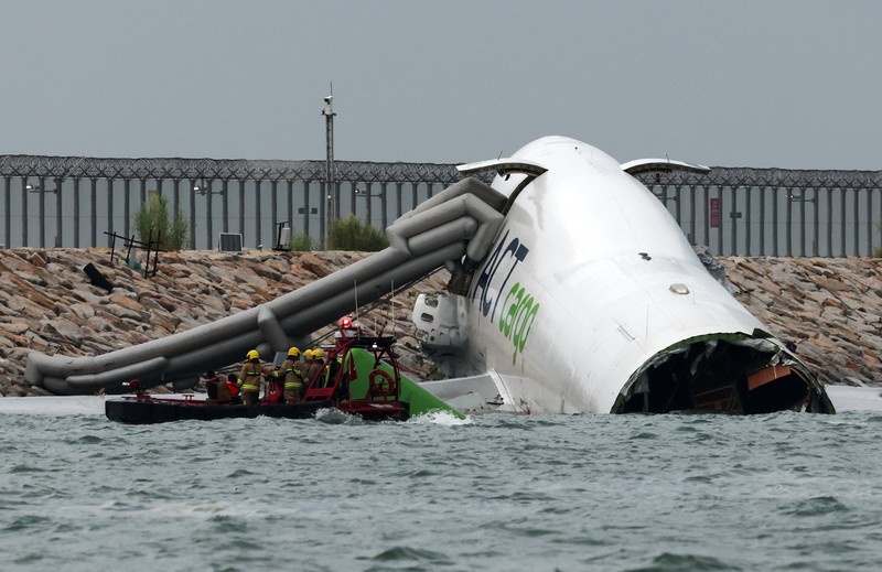 Sebuah pesawat kargo sebagian berada di laut setelah keluar dari landasan pacu saat mendarat di Bandara Internasional Hong Kong di Hong Kong, Cina, 20 Oktober 2025. Sebuah pesawat kargo sebagian berada di laut setelah keluar dari landasan pacu saat mendarat di Bandara Internasional Hong Kong di Hong Kong, Cina, 20 Oktober 2025. (REUTERS/Tyrone Siu)