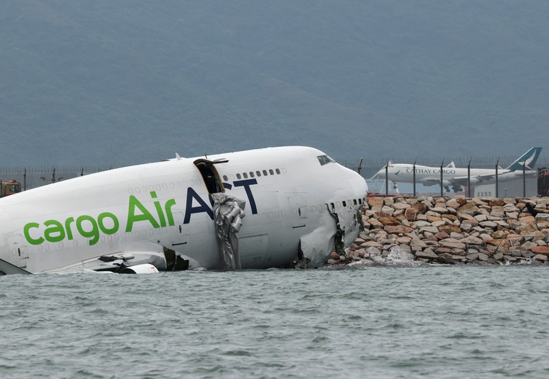 Sebuah pesawat kargo sebagian berada di laut setelah keluar dari landasan pacu saat mendarat di Bandara Internasional Hong Kong di Hong Kong, Cina, 20 Oktober 2025. Sebuah pesawat kargo sebagian berada di laut setelah keluar dari landasan pacu saat mendarat di Bandara Internasional Hong Kong di Hong Kong, Cina, 20 Oktober 2025. (REUTERS/Tyrone Siu)