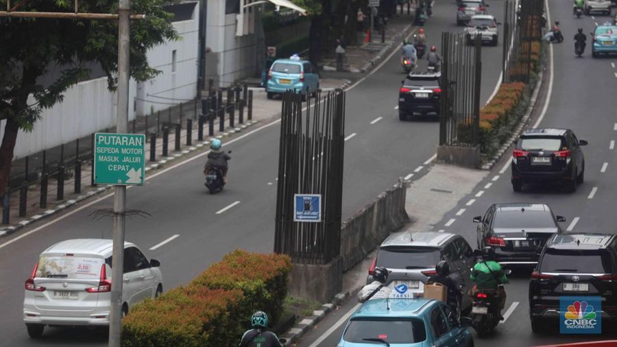 Pengendara melintas di samping tiang monorel yang mangkrak di kawasan Kuningan, Jakarta, Selasa (21/10/2025). (CNBC Indonesia/Muhammad Sabki)