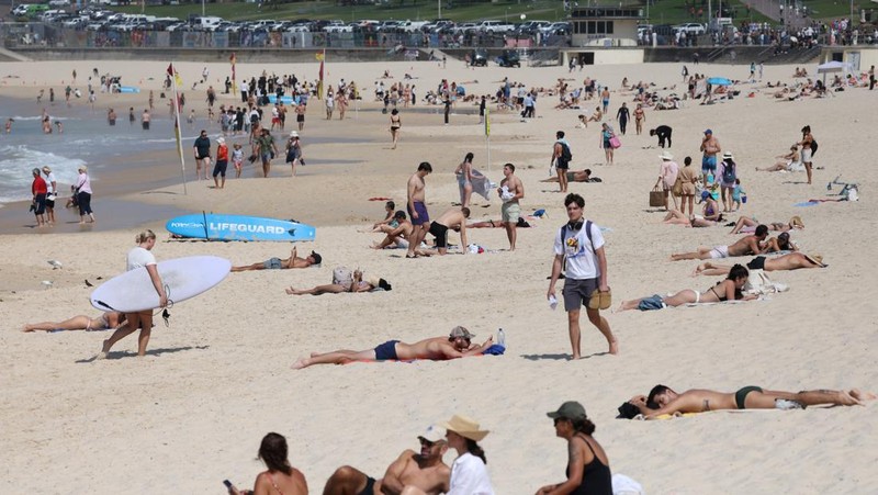 Orang-orang berjemur di Pantai Bondi, karena suhu diperkirakan mencapai puncaknya 39 derajat Celsius, menurut Biro Meteorologi, di Sydney, Australia, 22 Oktober 2025. (REUTERS/Hollie Adams)