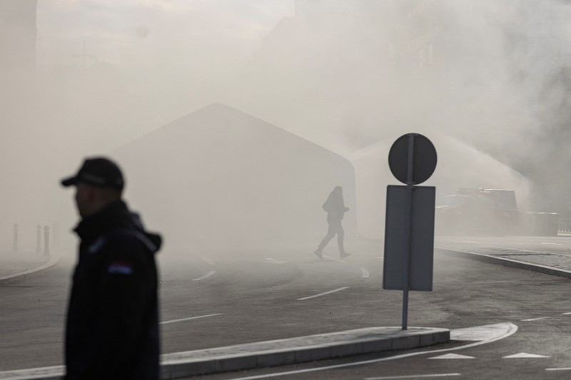 Petugas polisi mengamankan area saat asap mengepul dari tenda yang terbakar menyusul insiden di depan Parlemen di Beograd, Serbia, 22 Oktober 2025. Petugas polisi mengamankan area saat asap mengepul dari tenda yang terbakar menyusul insiden di depan Parlemen di Beograd, Serbia, 22 Oktober 2025. (REUTERS/Djordje Kojadinovic)