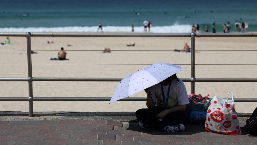 Orang-orang berjemur di Pantai Bondi, karena suhu diperkirakan mencapai puncaknya 39 derajat Celsius, menurut Biro Meteorologi, di Sydney, Australia, 22 Oktober 2025. (REUTERS/Hollie Adams)