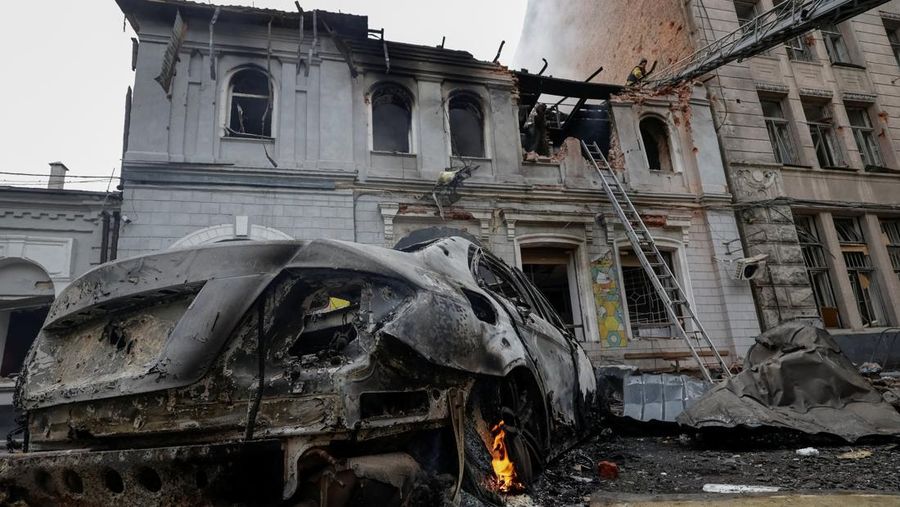 Seorang warga melihat mobil yang rusak saat petugas pemadam kebakaran bekerja di lokasi taman kanak-kanak yang terkena serangan pesawat tak berawak Rusia, di tengah serangan Rusia terhadap Ukraina, di Kharkiv, Ukraina, 22 Oktober 2025. Seorang warga melihat mobil yang rusak saat petugas pemadam kebakaran bekerja di lokasi taman kanak-kanak yang terkena serangan pesawat tak berawak Rusia, di tengah serangan Rusia terhadap Ukraina, di Kharkiv, Ukraina, 22 Oktober 2025. (REUTERS/Sofiia Gatilova)