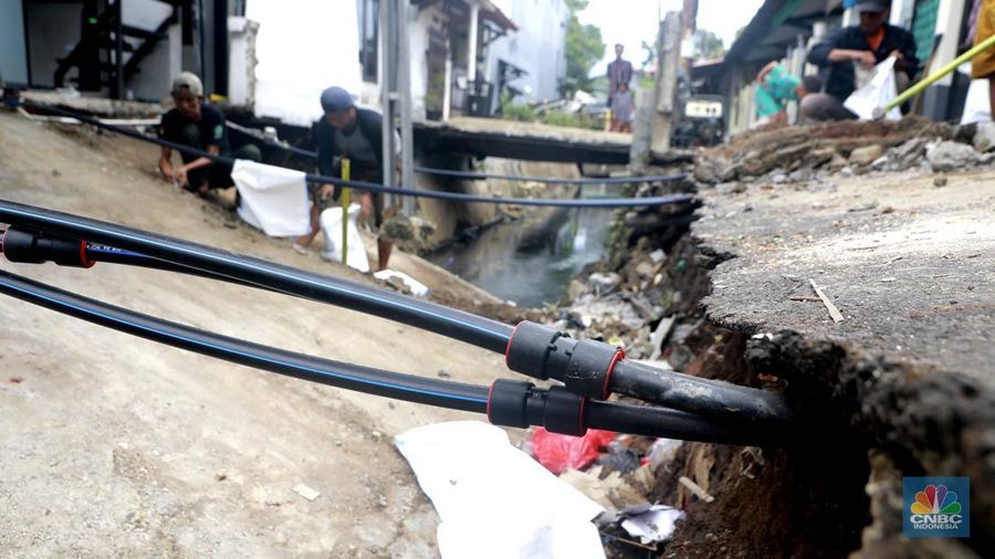 Sejumlah warga melakukan pengangkutan puing material jembatan warga di Gang Saluran yang ambruk, Matraman, Jakarta Timur, Kamis (23/10/2025). (CNBC Indonesia/Muhammad Sabki)