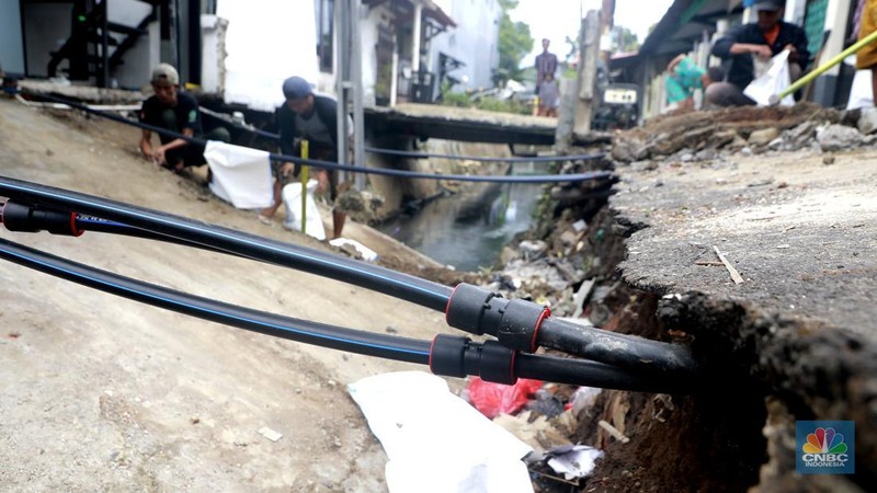 Sejumlah warga melakukan pengangkutan puing material jembatan warga di Gang Saluran yang ambruk, Matraman, Jakarta Timur, Kamis (23/10/2025). (CNBC Indonesia/Muhammad Sabki)