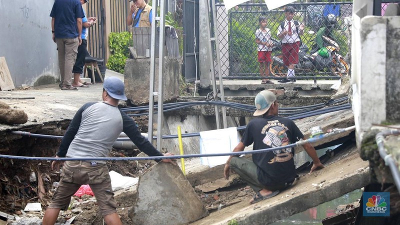 Sejumlah warga melakukan pengangkutan puing material jembatan warga di Gang Saluran yang ambruk, Matraman, Jakarta Timur, Kamis (23/10/2025). (CNBC Indonesia/Muhammad Sabki)