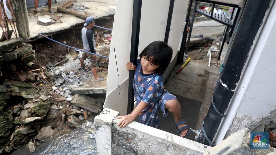 Sejumlah warga melakukan pengangkutan puing material jembatan warga di Gang Saluran yang ambruk, Matraman, Jakarta Timur, Kamis (23/10/2025). (CNBC Indonesia/Muhammad Sabki)