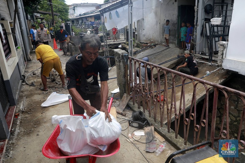 Sejumlah warga melakukan pengangkutan puing material jembatan warga di Gang Saluran yang ambruk, Matraman, Jakarta Timur, Kamis (23/10/2025). Sejumlah warga melakukan pengangkutan puing material jembatan warga di Gang Saluran yang ambruk, Matraman, Jakarta Timur, Kamis (23/10/2025). (CNBC Indonesia/Muhammad Sabki)