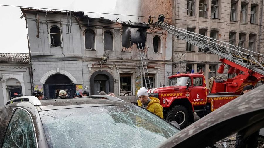 Seorang warga melihat mobil yang rusak saat petugas pemadam kebakaran bekerja di lokasi taman kanak-kanak yang terkena serangan pesawat tak berawak Rusia, di tengah serangan Rusia terhadap Ukraina, di Kharkiv, Ukraina, 22 Oktober 2025. Seorang warga melihat mobil yang rusak saat petugas pemadam kebakaran bekerja di lokasi taman kanak-kanak yang terkena serangan pesawat tak berawak Rusia, di tengah serangan Rusia terhadap Ukraina, di Kharkiv, Ukraina, 22 Oktober 2025. (REUTERS/Sofiia Gatilova)