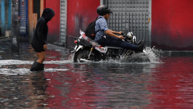 Seorang wanita berdiri di jalan yang tergenang air akibat hujan yang disebabkan oleh Badai Tropis Melissa, di Santo Domingo, Republik Dominika, 23 Oktober 2025. (REUTERS/Eddy Vittini)