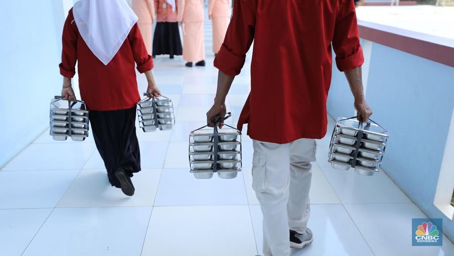 Petugas sekolah melalukan pembagian program (MBG) di Sekolah Dasar (SD) Angkasa 05 Halim, Jakarta, Jumat (24/10/2025). (CNBC Indonesia/Tri Susilo)