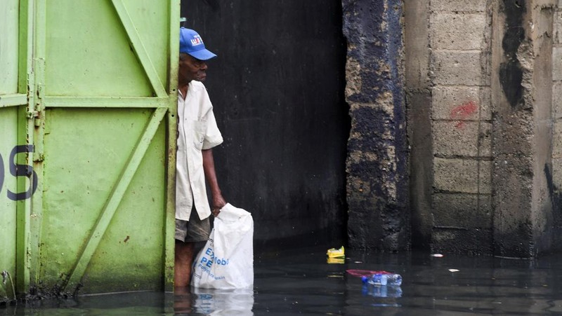 Seorang wanita berdiri di jalan yang tergenang air akibat hujan yang disebabkan oleh Badai Tropis Melissa, di Santo Domingo, Republik Dominika, 23 Oktober 2025. (REUTERS/Eddy Vittini)