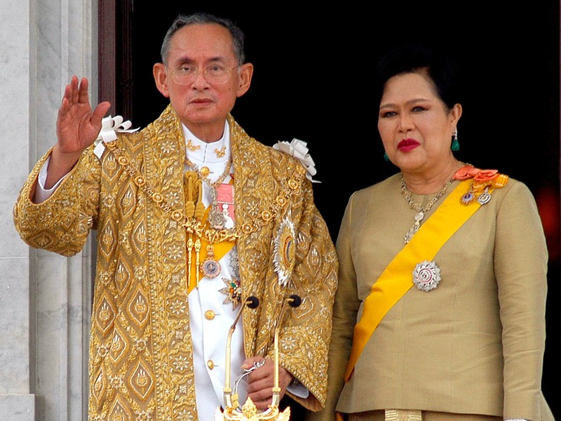 THAILAND-QUEENMOTHER/ FILE PHOTO: Britain's Queen Elizabeth II smiles as she greets Thailand's Queen Sirikit as the King Bhumibol Adulyadej looks on at a reception at the British Ambassador's residence in central Bangkok, Thailand October 30, 1996. REUTERS/Dylan Martinez/File Photo